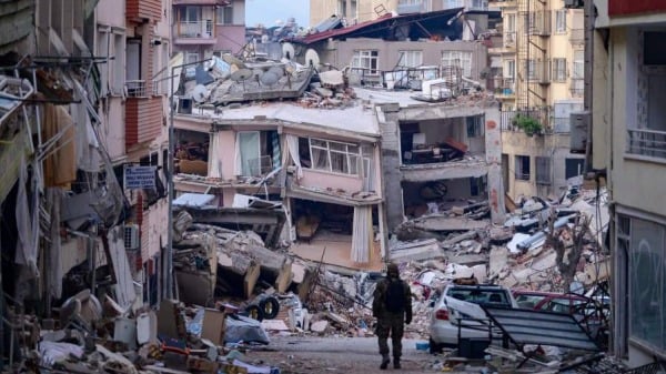 2023年2月12日，在土耳其东南部发生7.8 级地震后，一名土耳其士兵在哈塔伊被毁的建筑物中行走。