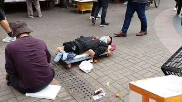 香港全面通关后，内地的乞丐倾巢而出赴港行乞，导致香港大街小巷充斥着各种假借卖艺、假扮伤残、卖身葬父等博取同情的乞丐。图为谁在路中间行乞的乞丐。（Shelly Ku/facebook）