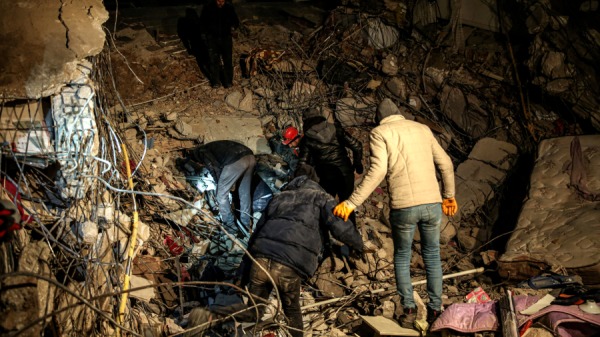 2023年2月9日在Türkiye的Hatay发生地震后，人们在被毁建筑物中进行搜救工作。