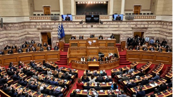 2022年4月7日，乌克兰总统弗拉基米尔．泽连斯基 (Volodymyr Zelensky) 在雅典向希腊议会发表虚拟讲话时，希腊国会议员在聆听。希腊呼吁国际刑事法院 (ICC) 调查乌克兰港口城市马里乌波尔的“战争罪”。