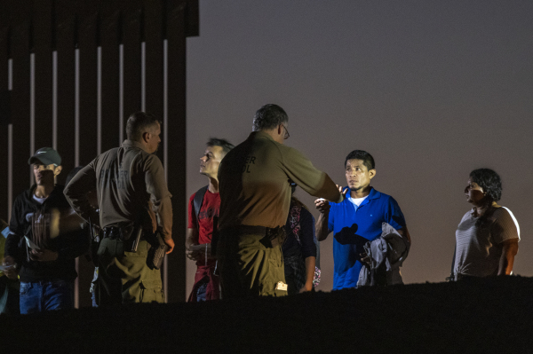 2022年9月27日，美国边境巡逻人员在美墨边境围栏旁拘留非法入境人员。