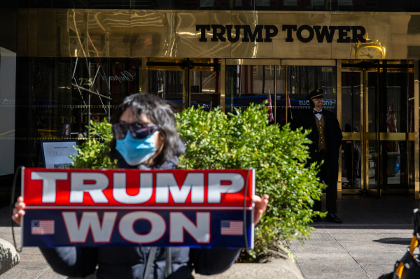 2023年3月20日，一位川普支持者在川普大廈前近舉著「川普贏了」的標語牌。