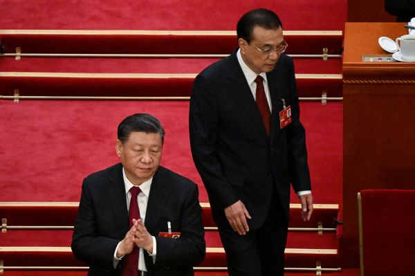2023年3月5日，中共国务院总理李克强（右）在北京人民大会堂举行的全国人民代表大会（NPC）开幕式上发表工作报告后走过中共国家主席习近平（左）身边。