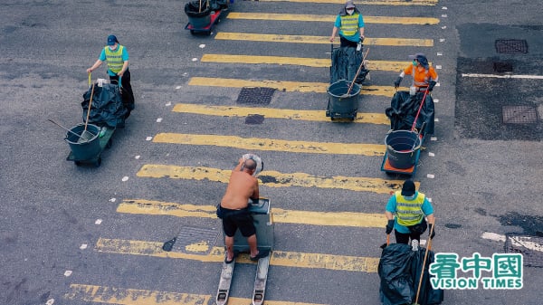 有深圳居民直言，月薪两、三万，去香港捡垃圾都行，“我们内地人很挨得苦”。图为香港街头的垃圾工人。（摄影：庞大卫/看中国）