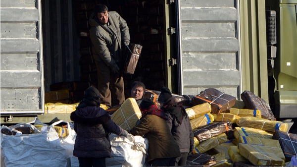 2013年2月7日，朝鮮工人在中國丹東市對面的新義州鎮附近的鴨綠江岸邊卸下一輛卡車。