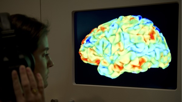 一位女士正在觀看功能磁共振圖像 (fMRI)(MIGUEL MEDINA/AFP via Getty Images)