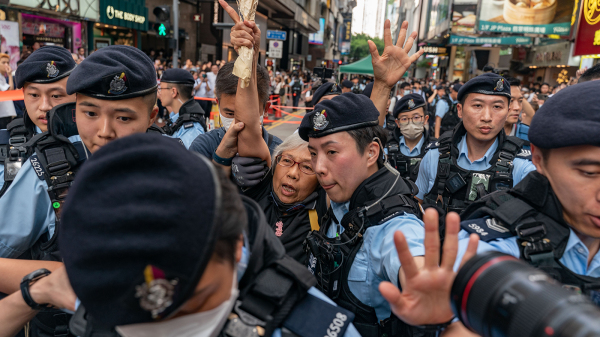 王婆婆手持鮮花到銅鑼灣，隨即被警方帶上警車。（圖片來源：Getty Images）