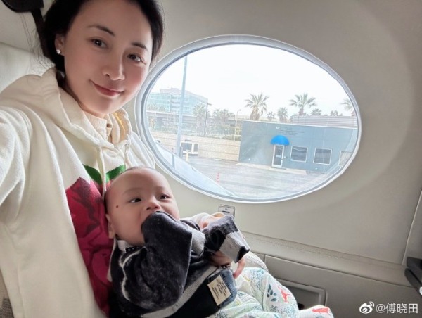 4月10日，傅曉田曬出抱著兒子在飛機上拍攝的照片。