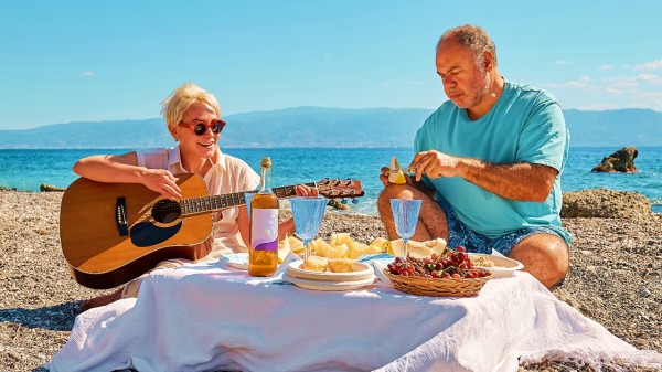 夏天在海邊彈吉他吃水果的夫妻