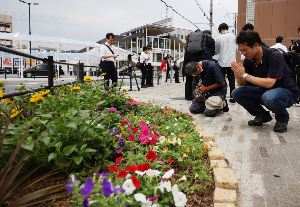 7月8日，日本前首相安倍晉三逝世1周年，民眾在奈良市大和西大寺站外悼念。（圖片來源：STR/JIJI PRESS/AFP/Getty Images）