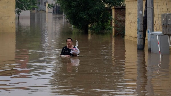 中国河北涿州民众在滔滔洪水中逃生。（图片来源：Kevin Frayer/Getty Images）