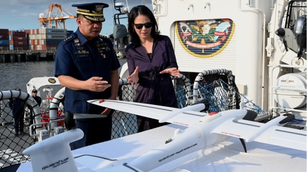 2024年1月11日，菲律賓海岸警衛隊海軍上將羅尼•吉爾•加萬（左）和德國外交部長安娜萊娜•貝爾博克（右）在菲律賓海岸警衛隊總部禮節性訪問BRP Gabriela Silang 期間，觀看他們捐贈給菲律賓海岸警衛隊的Trinity F90+ 無人機。