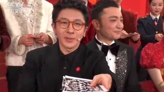 刘谦（左）表演扑克牌魔术，旁边主持人尼格买提却失灵，表情逐渐失控。