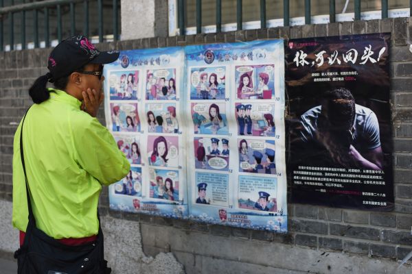 2017年5月23日，北京的一條小巷裡，一名婦女正在觀看一幅警告當地居民提防外國間諜的宣傳漫畫。