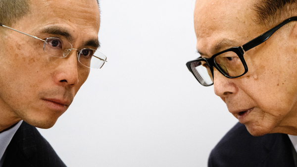 圖為2018年，香港首富李嘉誠（右）與長子長實主席李澤鉅（左）出席記者會。（圖片來源：Getty Images）