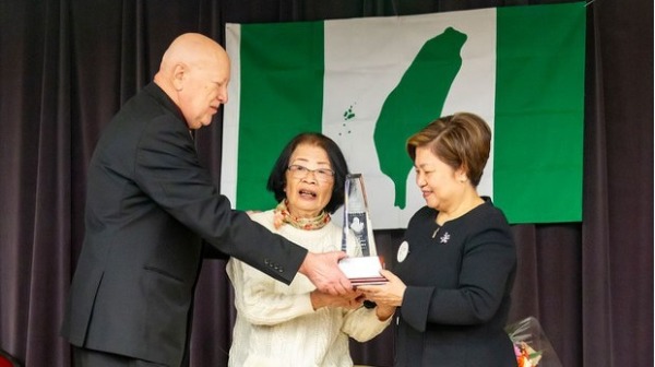 2024年3月23日，港加聯主席馮玉蘭(右)從林哲夫妻子郭哲子(中)和加拿大臺灣人權協會會長史邁克(Michael Stainton，左)手中，接過人權獎