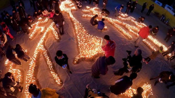 1月16日，兵库县伊丹市民众在纪念“坂神大地震”29周年集会上点燃蜡烛，悼念能登半岛地震罹难者。