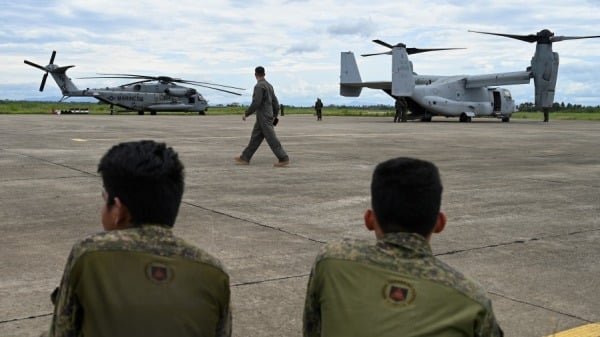 2023年8月3日，士兵在菲律賓卡加延拉爾洛空軍基地觀看一架美國 CH53 海種馬直升機和 V-22 魚鷹即將起飛。