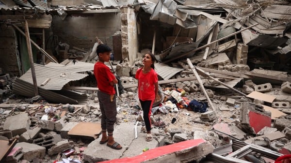 4月27日，巴勒斯坦兒童站在拉法一棟房屋廢墟中，與此同時，以色列與哈馬斯仍在加沙地帶激戰。