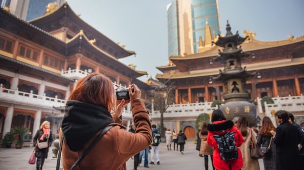 旅游妇女在中国上海市中心静安寺拍照。