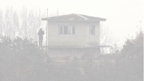 2006年12 月13 日，一名朝鮮士兵站在薄霧籠罩的崗哨上，眺望板門店邊境村莊的南側，板門店位於首爾以北自朝鮮戰爭以來分隔兩國的非軍事區。