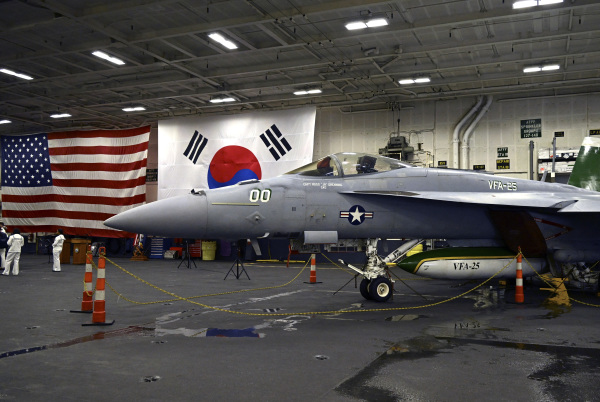 2024年6月22日，停泊在釜山海军基地的美国西奥多－罗斯福号核动力航空母舰（CVN 71）的机库中停放着一架F－18战斗机。