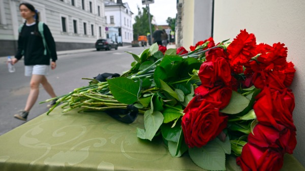 2024年6月24日，达吉斯坦发生恐怖攻击后，一名妇女走过达吉斯坦驻莫斯科代表处前摆放的花朵。
