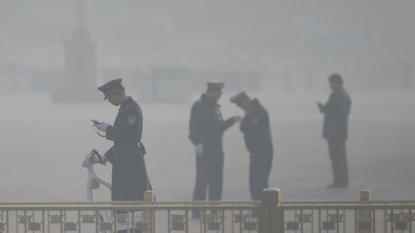 2013 年 3 月 8 日，中国北京，天安门广场，代表们在严重污染的空气中参加中国人民政治协商会议全体会议。