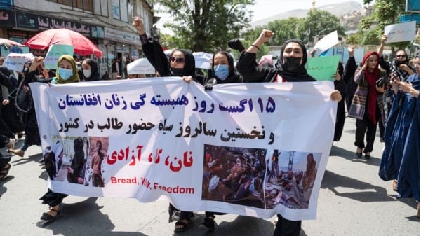 2022年8月13日，在喀布尔举行的妇女权利抗议活动中，阿富汗妇女举着标语牌游行，高呼“面包、工作、自由”的口号。抗议者，并向空中开枪。